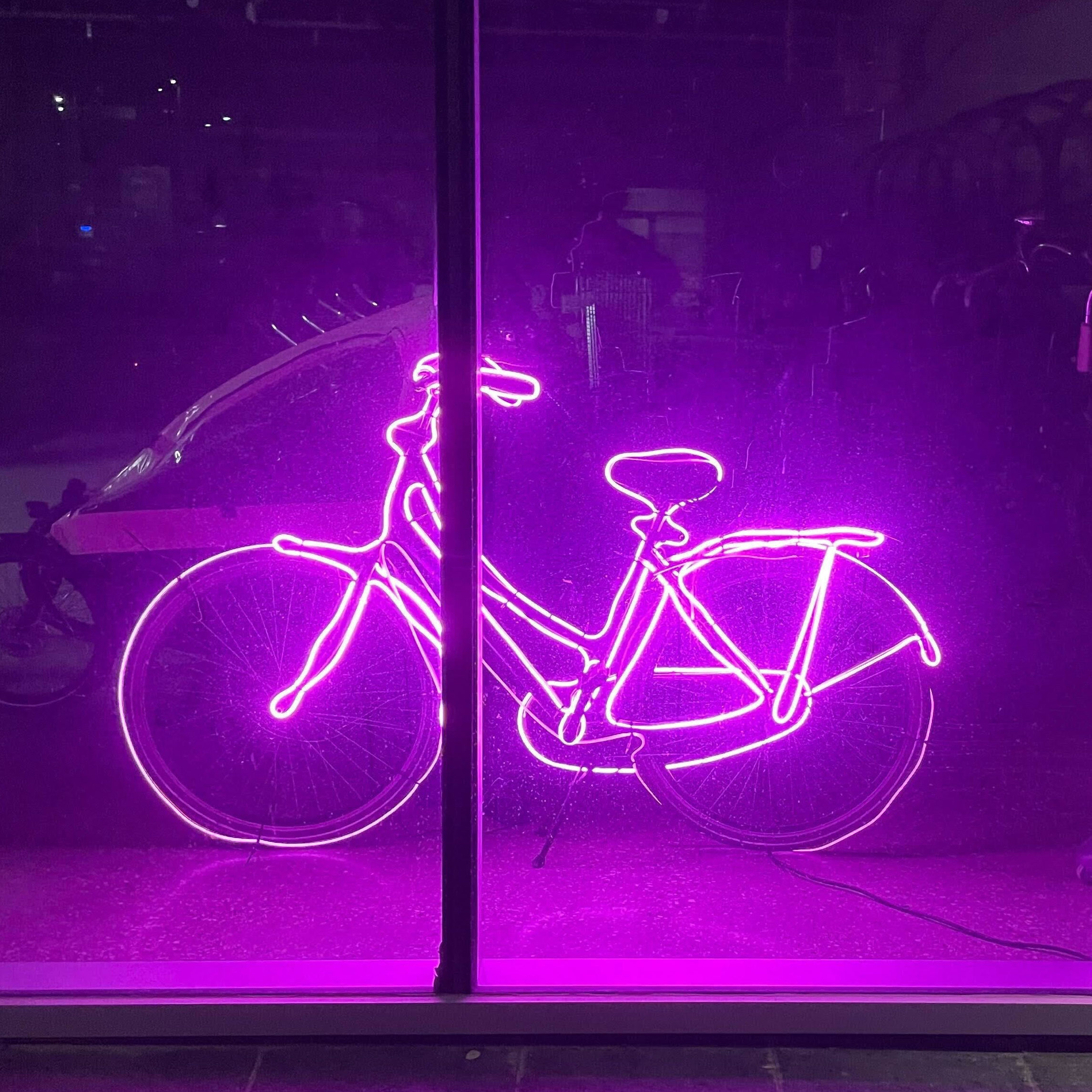 Pink neon bicycle in the window of Sherbrook location